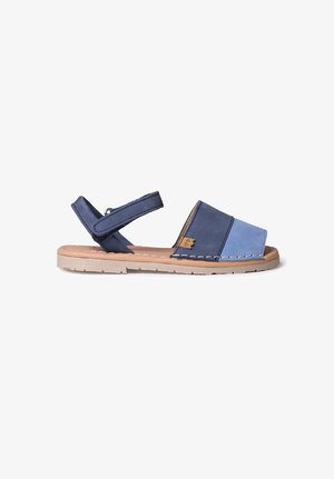 Zweifarbig blaue Sandalen mit verstellbarem Riemen, offener Zehenpartie und beiger Sohle. Mit genähten Details entlang der Sohleneinfassung.