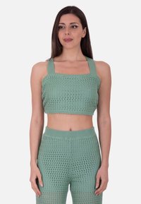 Mørkegrøn strikket cropped top med brede stropper, der har et tekstureret åbent vævdesign. Kombinationen med matchende højttalende bukser.