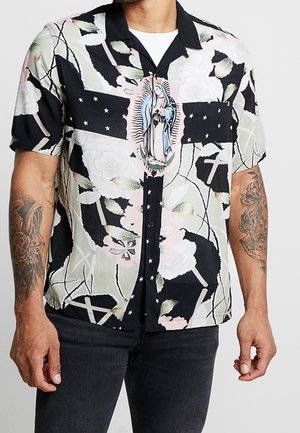 Koszula z krótkim rękawem w czarnym kolorze z kwiatowymi i krzyżowymi wzorami, z centralną ilustracją postaci. Wykonana z gładkiego, lekkiego materiału.