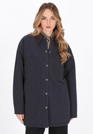 Mørkeblå oversized jakke med en brun kordfløjlskrave, frontknapper og to brystlommer; glat tekstur, afslappet pasform.