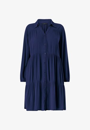 Námořnický modrý košilový šaty vyrobené z měkké tkaniny, s dlouhými rukávy, vrstevnatou siluetou a límečkem. Texturované, s viditelnými švy.