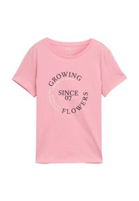 Camiseta de algodón rosa con mangas cortas, escote redondeado, que presenta un estampado gráfico circular negro con el texto: "CRECIENDO FLORES DESDE 07."