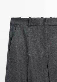 Graue Wollhose mit flatem Vorderteil, Seitentaschen und einem taillierten Bund mit Gürtelschlaufen. Glatte Textur und maßgeschneiderte Form.