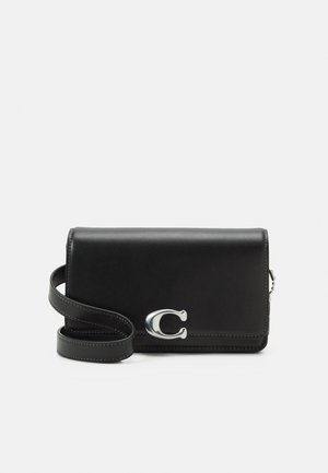 Borsa a spalla nera in pelle con una texture liscia, hardware in argento e un accentuato motivo a forma di C. Tracolla regolabile con dettagli di cucitura.