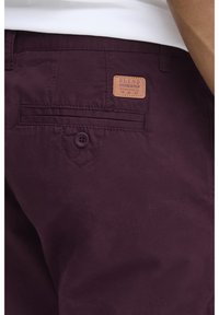 Burgundy kratke hlače od pamuka s teksturiranim završetkom, koje imaju stražnji dzep i kožni logotip s ugraviranim tekstom.