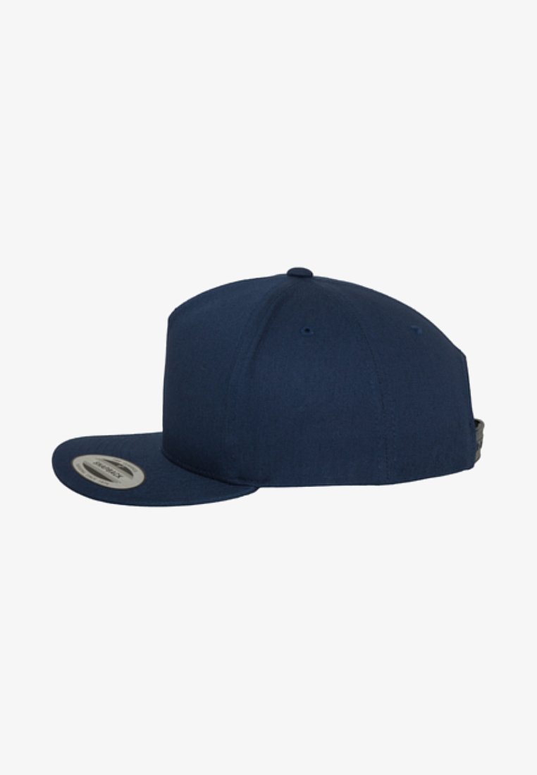 Navy blue cap with a flat brim, made of fabric. Includes a round logo on the side and ventilation holes. Simple, unadorned design.