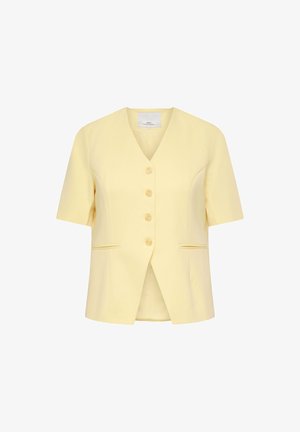 Blouse jaune pâle à manches courtes avec col en V, quatre boutons à l'avant et deux poches fendues sur les côtés, présentée sur un fond blanc.