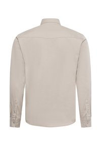 Light beige long-sleeve shirt with a button-down collar, single rounded yoke, and buttoned cuffs. Smooth fabric with no visible patterns.