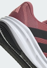 Running shoe with a pink mesh upper, featuring black accents. Thick white midsole labeled "CLOUDFOAM" and textured black rubber outsole.