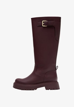 Burgunderfarbene kniehohe Gummistiefel mit flacher Sohle, seitlichem Schnallen-Detail und strukturiertem Grip, mit einer glatten Oberfläche und robuster Konstruktion.
