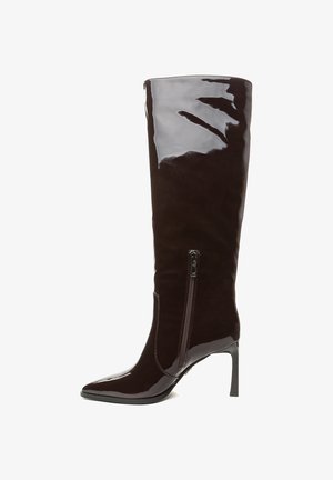 Botas de charol marrón oscuro hasta la rodilla, con punta afilada, que cuentan con un cierre lateral y detalles de costura sutiles en la zona del zipper. Diseño con tacón.