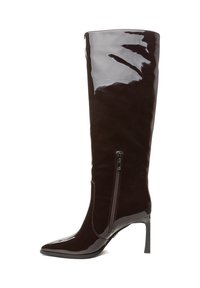 Botte en cuir verni brun foncé hauteur genou, avec bout pointu, talon haut stilettos et détail décoratif de fermeture éclair latérale. Finition lisse et brillante.