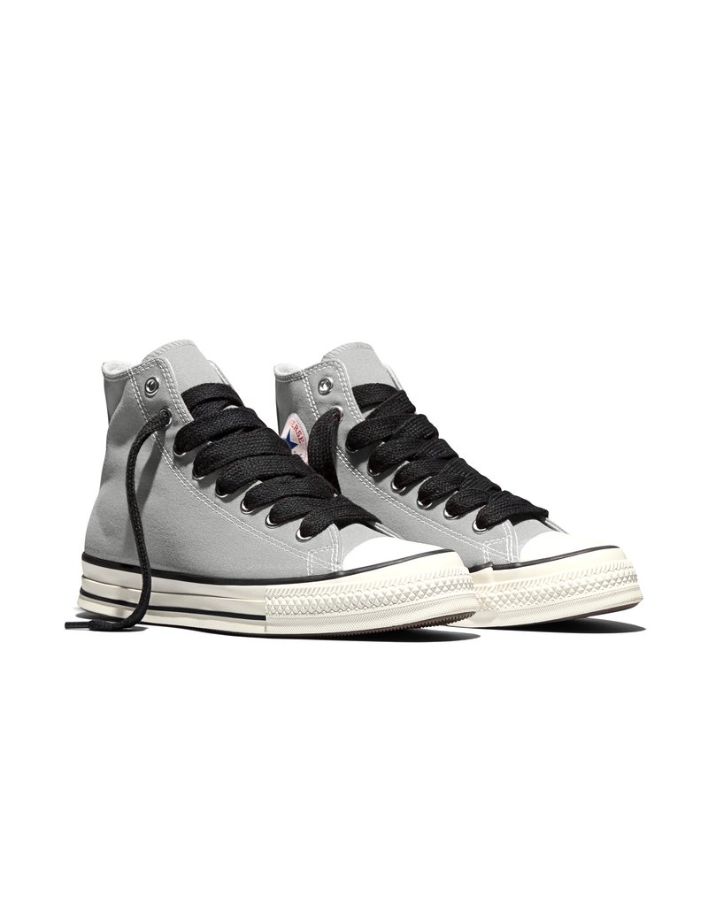 Coppia di sneakers alte in tela grigia con lacci neri e suola in gomma bianca su sfondo bianco.