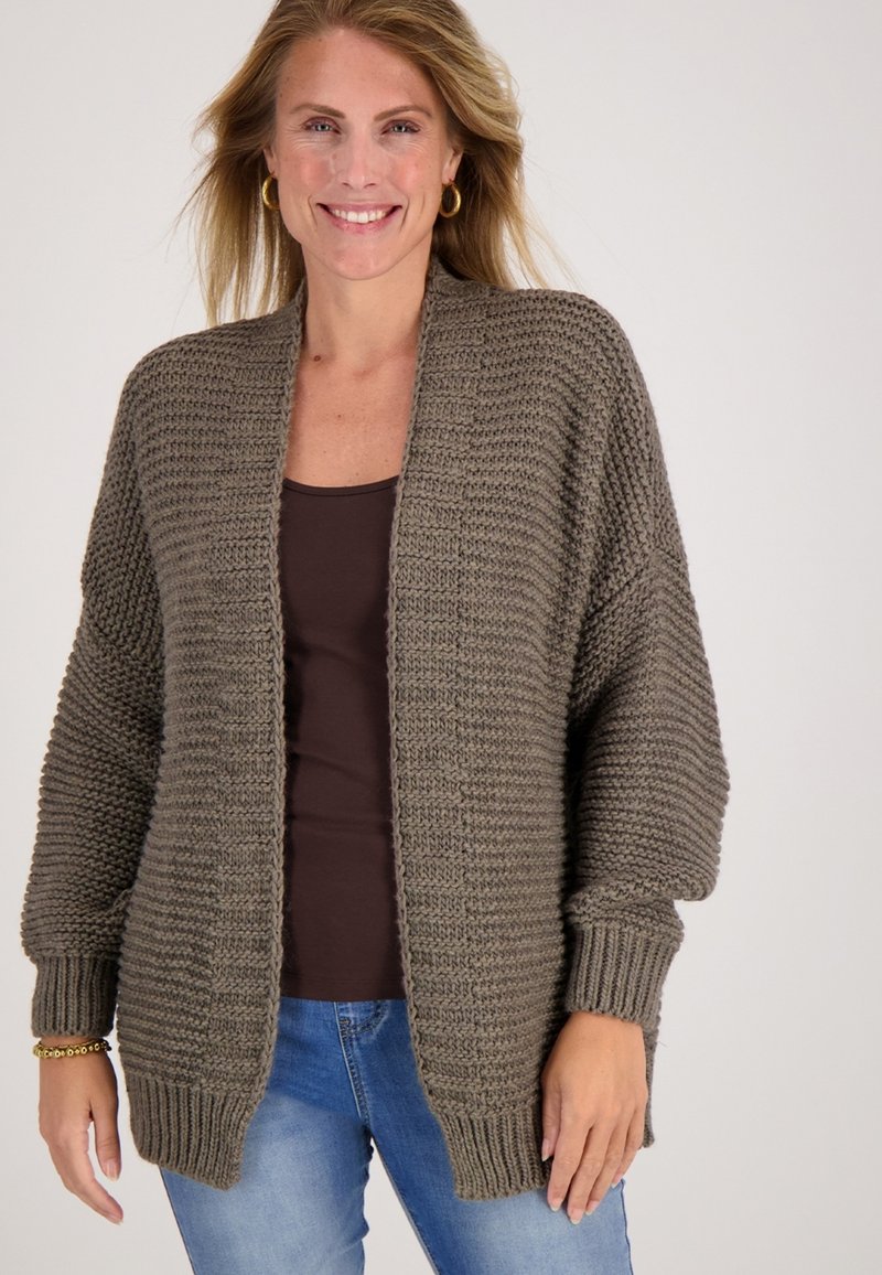 Gebreid cardigan in gedempt olijfgroen met textuurstrepen in horizontale richting, open voorkant en geribde manchetten en zoom. Draagt over een bruine top.