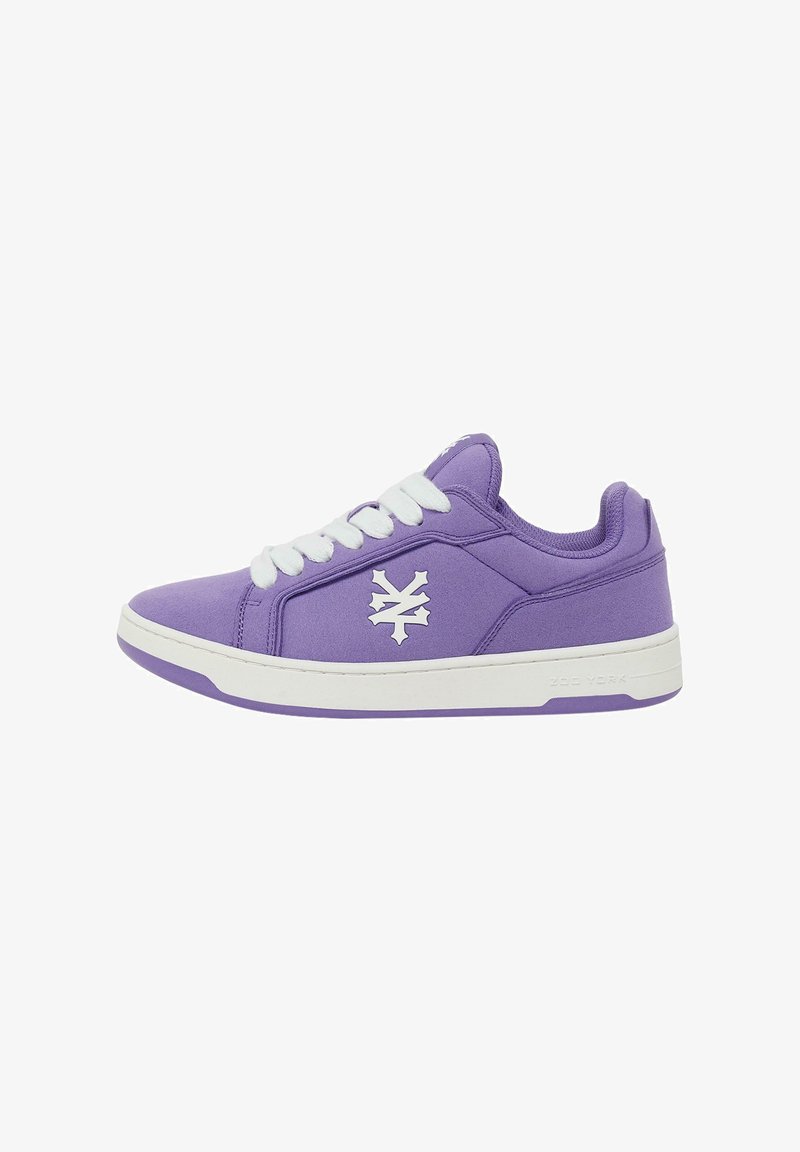 Lila vászon sneaker fehér gumitalppal, fehér fűzőkkel és oldalsó logóval. Középmagas dizájn és sima textúra.
