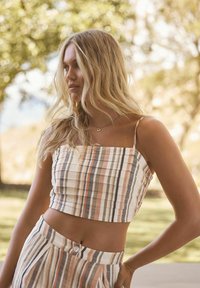 Gestreept crop top in beige, perzik en grijstinten met dunne bandjes. Textuurstof met verticale lijnen. Bijpassende hoge taille broek.
