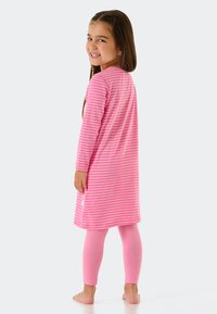 Rosa gestreiftes Nachtkleid mit langen Ärmeln und lockerer Passform, kombiniert mit einfarbigen rosa Leggings, beide aus weichem Stoff gefertigt.