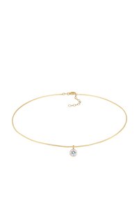 Guldkæde med et delikat design, der har en rund, klar ædelsten ved midten. Letvægts, struktureret finish.