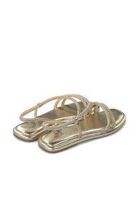 Sandali dorati con sottili cinturini decorati e suola piatta. Finitura metallica con una texture lucida. Accenti decorativi sui cinturini superiori.