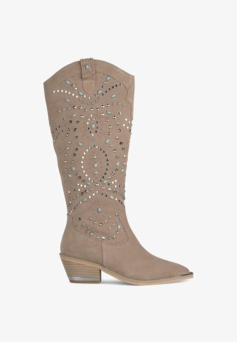 Beżowe zamszowe kowbojki z ostrym noskiem, ozdobione dekoracyjnymi ćwiekami i turkusowymi akcentami w wirującym wzorze, oraz z niskim obcasem.
