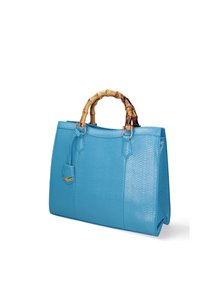 Borsa a tracolla in pelle blu con texture, manico in bamboo, dettagli in metallo dorato e un piccolo tag attaccato; forma rettangolare strutturata.