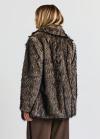 Cappotto in pelliccia sintetica in tonalità di marrone con una texture shaggy, colletto ampio e vestibilità leggermente oversize, visto da dietro.