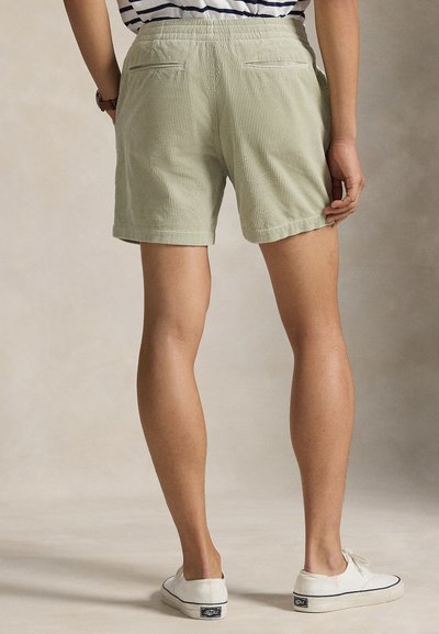 Βερμούδα από κορδούρι σε ελιά πράσινο με άνετη εφαρμογή, μήκος μέχρι το μέσο του μηρού, με δύο πίσω τσέπες και διπλωμένο τελείωμα.