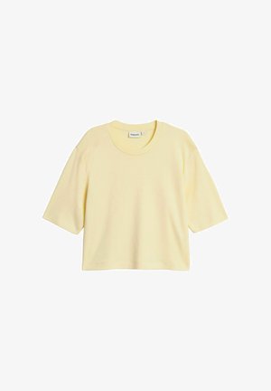 Vaaleankeltainen, lyhythihainen, lyhyt T-paita pyöreällä pääntiellä, väljä istuvuus ja yksivärinen.