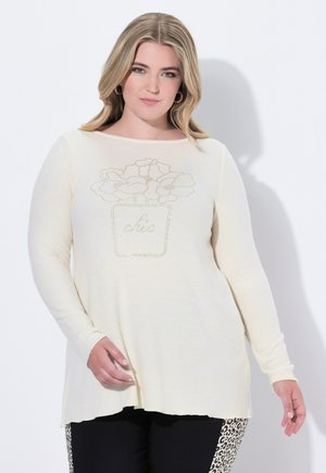 Cremfarbendes Langarmshirt mit floralem Design aus Strass und dem Wort "chic". Weicher Stoff, entspannter Schnitt, runder Ausschnitt.