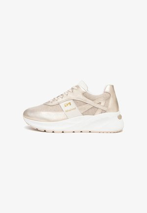Beige en gouden lage sneaker met witte zool, beige veters en een merkpaneel aan de zijkant, gezien vanaf de buitenkant.