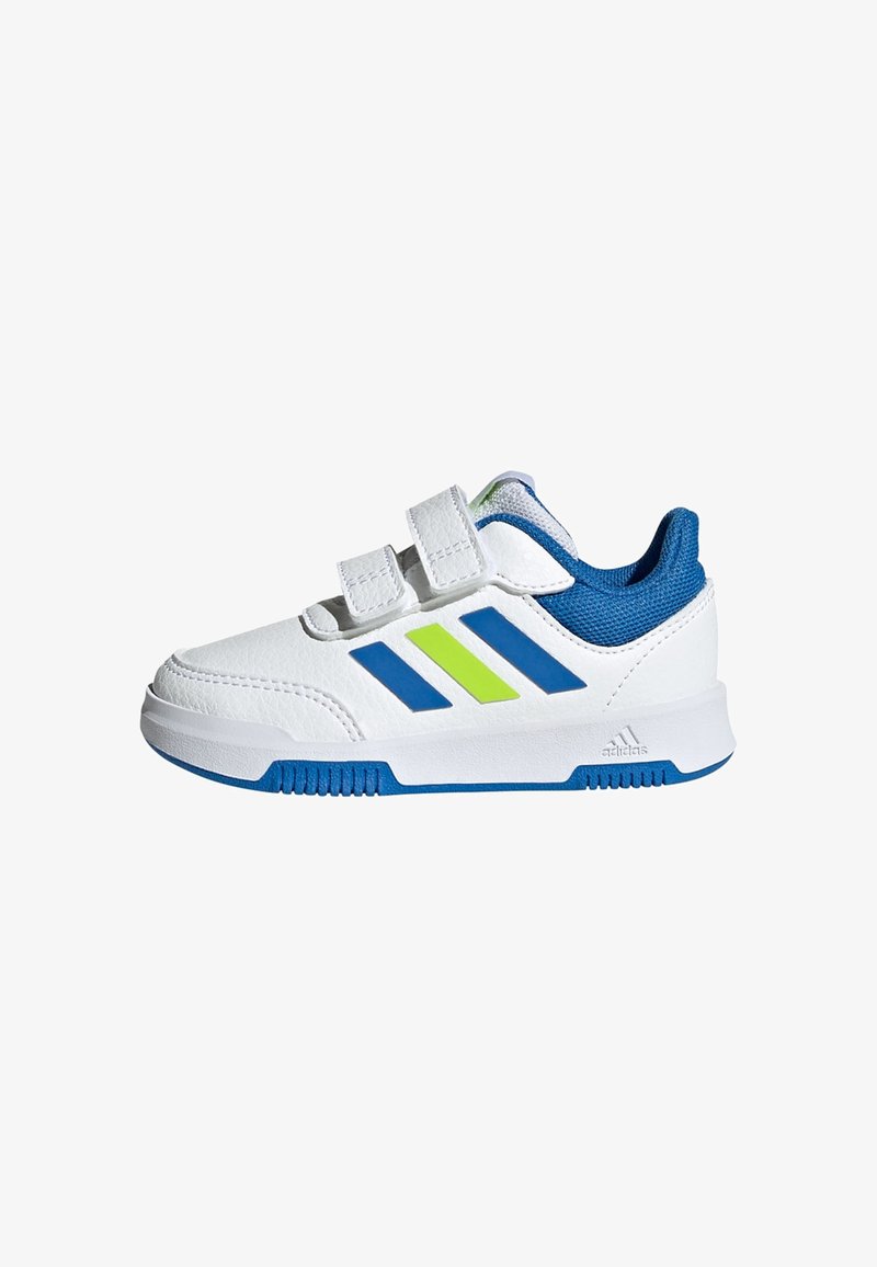 Witte sportschoenen met blauwe accenten, voorzien van twee klittenbandsluitingen, een blauwe ademende tong en groene en blauwe strepen aan de zijkanten.