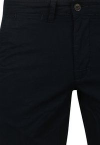 Donkerblauwe katoenen broek met een rechte snit, voorzien van een knoopsluiting en riemlussen. Glad oppervlak met minimale stikseldetails.
