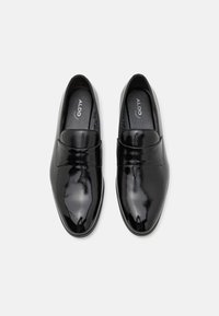 Loafers negri cu un upper lucios, texturat, având o bandă din piele netedă peste glezna piciorului și un design cu vârf rotunjit.