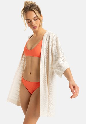 Lightweight, open-knit cream kimono with short sleeves, layered over a textured orange bikini top and matching bottoms.