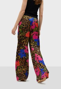 Wijduitlopende broeken hebben een leoprint basis met levendige bloemenpatronen in roze, blauw en groen. Gemaakt van een lichtgewicht stof met een gladde textuur.