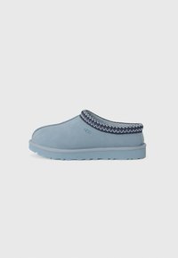 Scarpe slip-on in suede blu con un accento testurizzato blu navy lungo il collo e una suola in gomma azzurra, caratterizzate da una punta arrotondata e dettagli cuciti.
