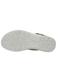 Shoe sole with a textured white rubber material, featuring a patterned tread for grip. Side has yellow and gray fabric accents.