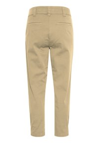 Beige bomullbyxor med slim fit, avsmalnande ben, två bakfickor och bälteshällor. Ren design utan mönster eller utsmyckningar.