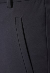 Navy fabric close-up featuring a textured surface with a side pocket and stitched detailing, showcasing a smooth finish and clean lines.