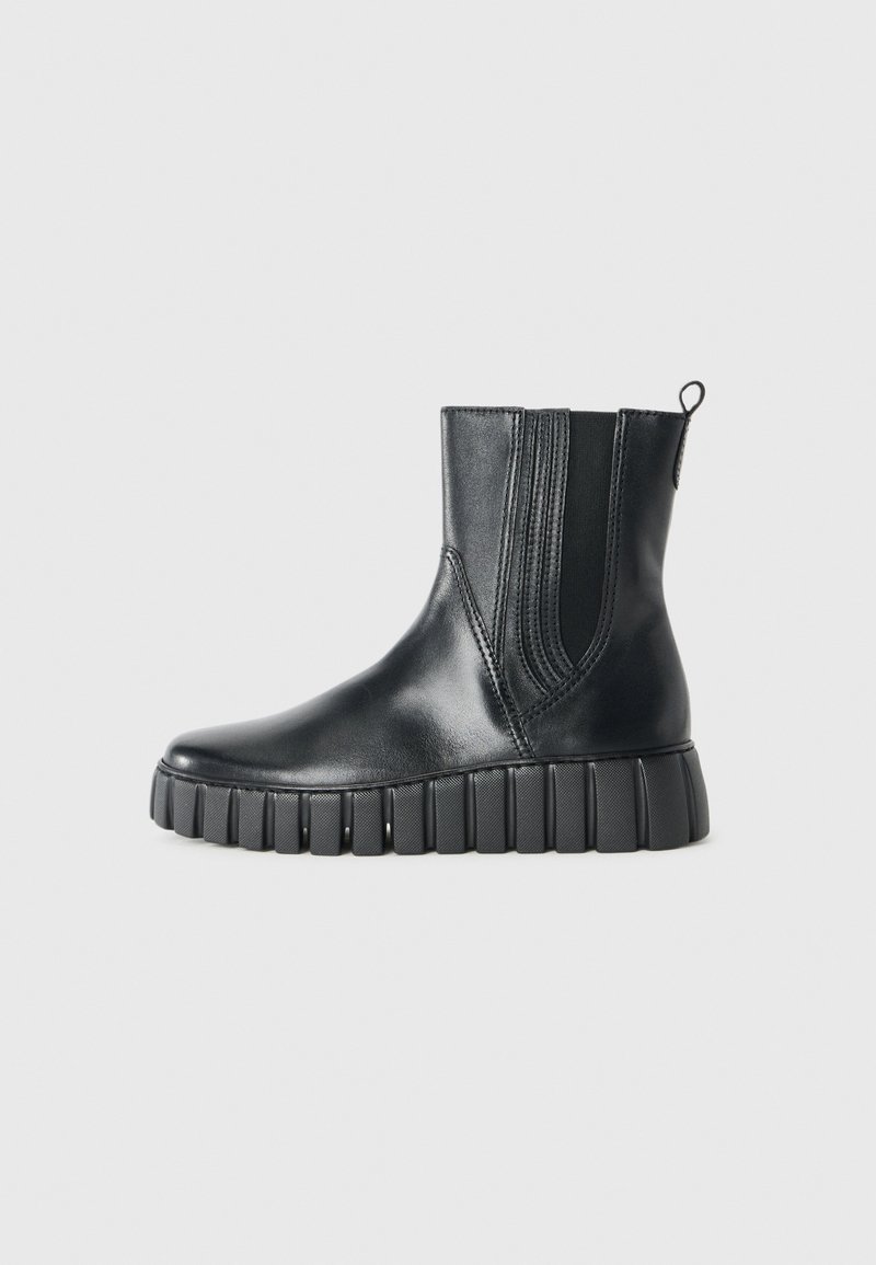 Botines negros de cuero suave con paneles laterales elásticos, punta redonda y suela de goma gruesa y estriada.