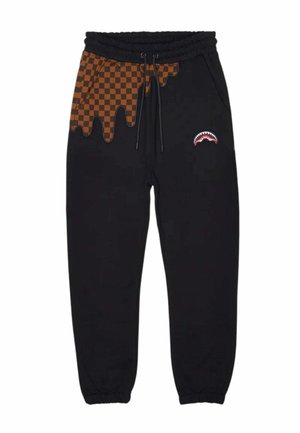 Pantaloni jogger neri con motivo a quadri arancioni e neri a goccia sulla parte superiore sinistra e una piccola grafica di bocca di squalo sulla coscia destra.