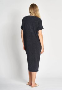 Dunkelgraues, übergroßes T-Shirt-Kleid mit kurzen Ärmeln, knielang, weiche Textur und rundem Ausschnitt. Keine sichtbaren Muster oder Akzente.