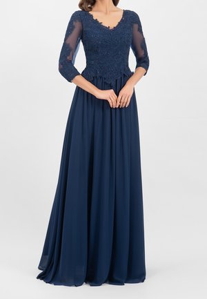 Navyblaues Abendkleid mit einem enganliegenden Spitzenoberteil und transparenten Dreiviertelärmeln, der fließende Rock reicht bis zum Boden und ist mit zarten Perlenverzierungen ausgestattet.