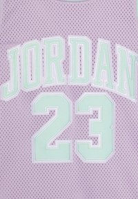 Lilla võrgumaterjalist jerseyt, millel on valged ja müntrohelised "JORDAN" teksti numbril "23" kohal, tepitud detailid ja hingav tekstuur.