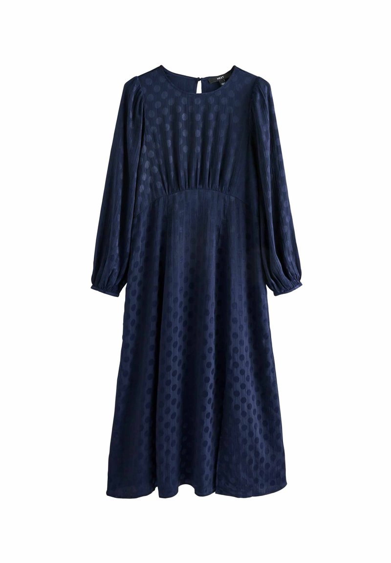 Rochie bleumarin cu mâneci lungi tip puff, decolteu rotund și textură cu buline. Prezintă o talie strânsă și fustă până la genunchi.