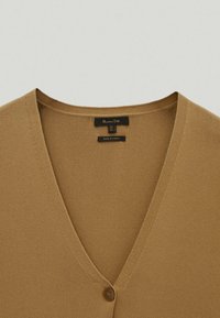 V-Ausschnitt Strickjacke in Hellbraun. Aus weichem Material mit glatter Textur und einer einzelnen Knopfverschluss an der Vorderseite.