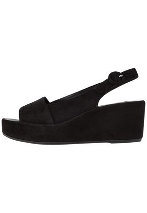 Black suede slingback wedge sandal with open toe and round buckle strap.
