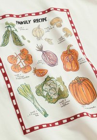 Cloth with illustrations and handwritten labels of vegetables including pea pods, garlic, mushrooms, tomatoes, onion, red pepper, leeks, cauliflower, and pumpkin.