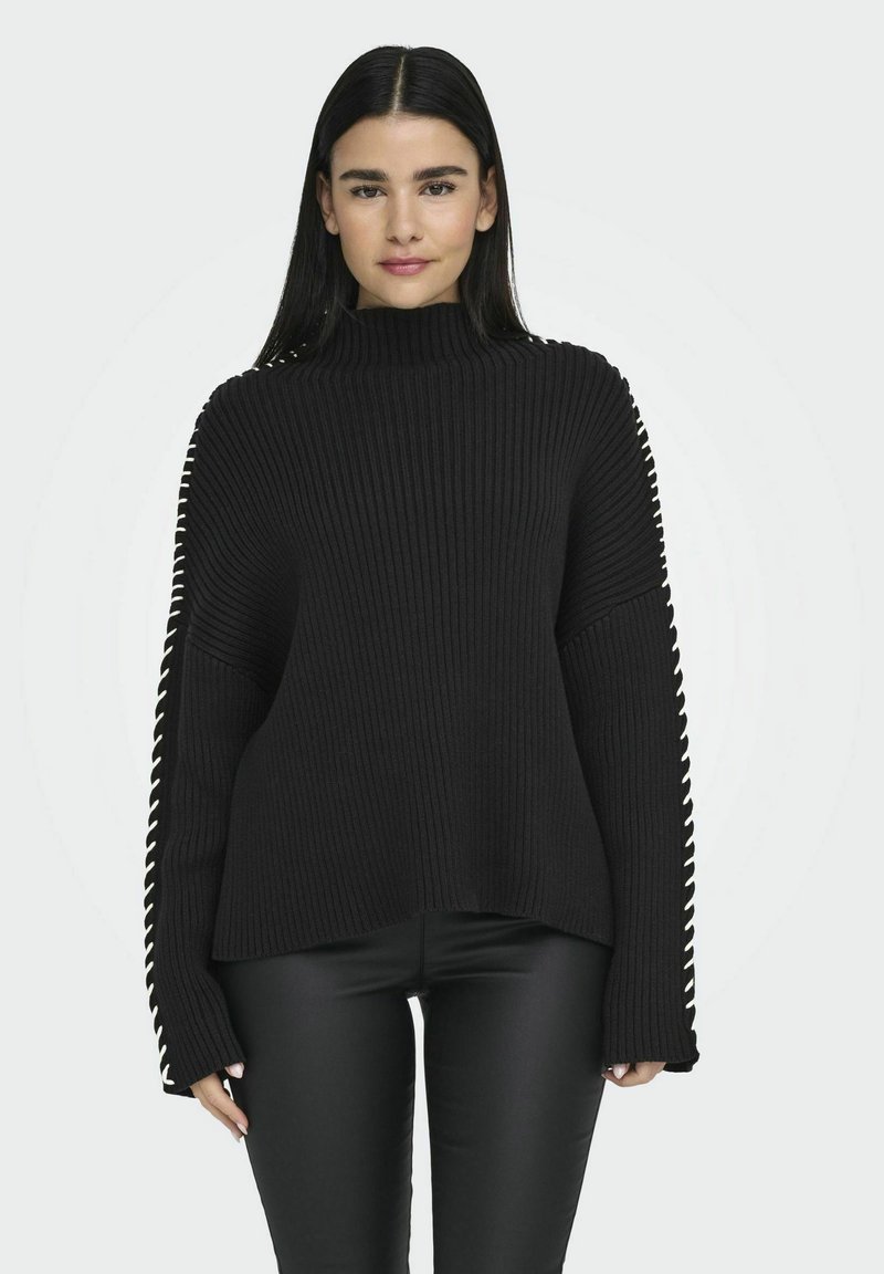 Maglione a collo alto nero a costine con maniche lunghe, caratterizzato da cuciture decorative bianche lungo le cuciture laterali e una vestibilità comoda.