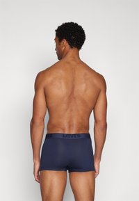 Levi's sötétkék boxer alsónadrág fekete logós derékkal. Simaság, testhezálló fazon és közepes derékállás jellemzi.